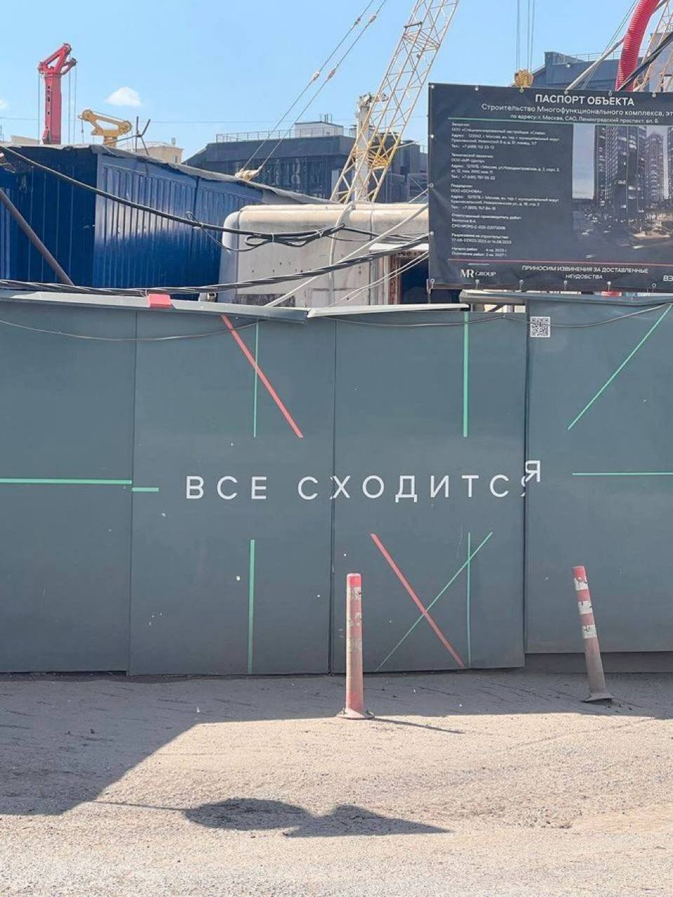 Все сходится Строительный забор с надписью "Все сходится" и дорожные стойки