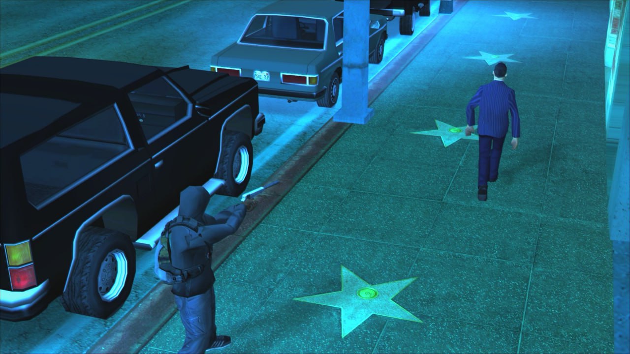 Убийца целится в человека в синем костюме в GTA Мужчина в синем костюме идет по "Аллее славы" в GTA, в то время как другой человек целится в него из пистолета.