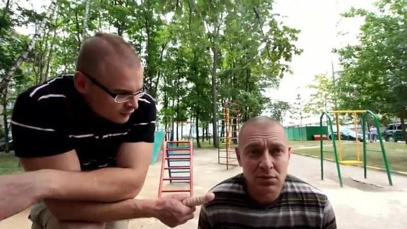 Лысый мужик показывает пальцем на члена Двое лысых мужчин на детской площадке, один из них указывает на другого пальцем, похожим на член.