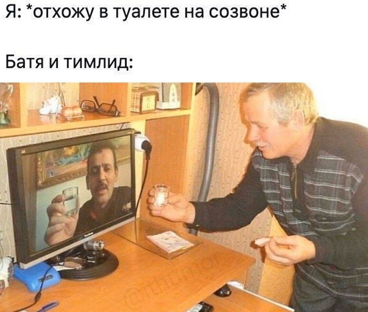 Отхожу в туалете на созвоне Мужчина на мониторе пьет воду, а другой мужчина рядом с монитором протягивает ему рюмку.