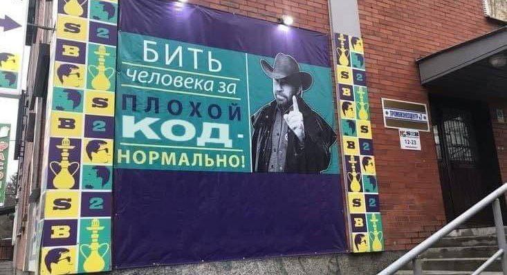 Бить человека за плохой код Баннер с мужчиной в ковбойской шляпе и надписью "Бить человека за плохой код – нормально!"