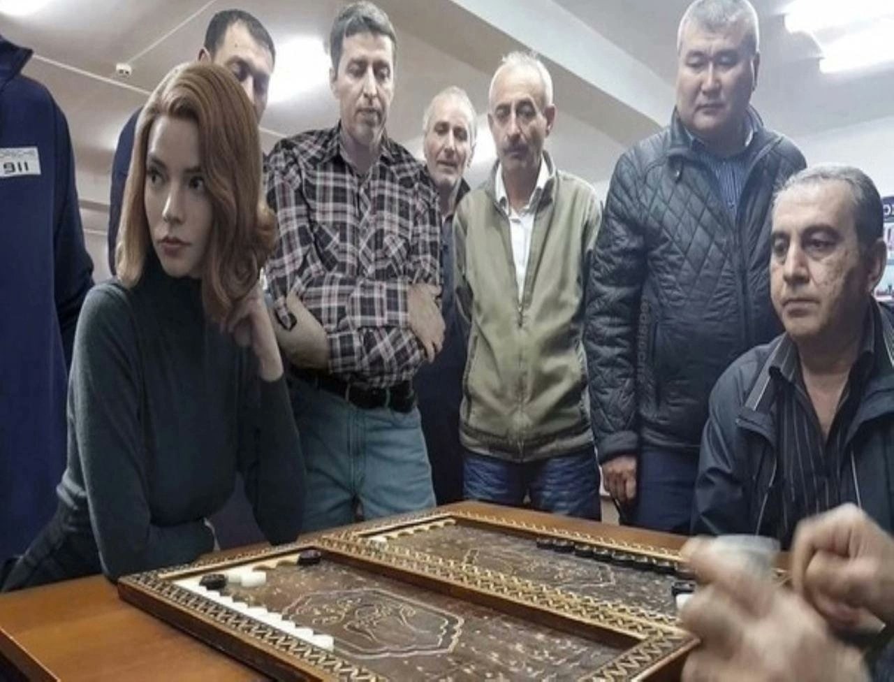 Бет Хармон играет в нарды Бет Хармон из сериала «Ход королевы» смотрит на игру в нарды с группой мужчин, что является отсылкой к её шахматным способностям.