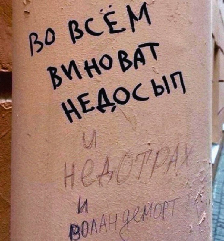 Надпись на стене «Во всём виноват недосып» с приписками о других возможных причинах.