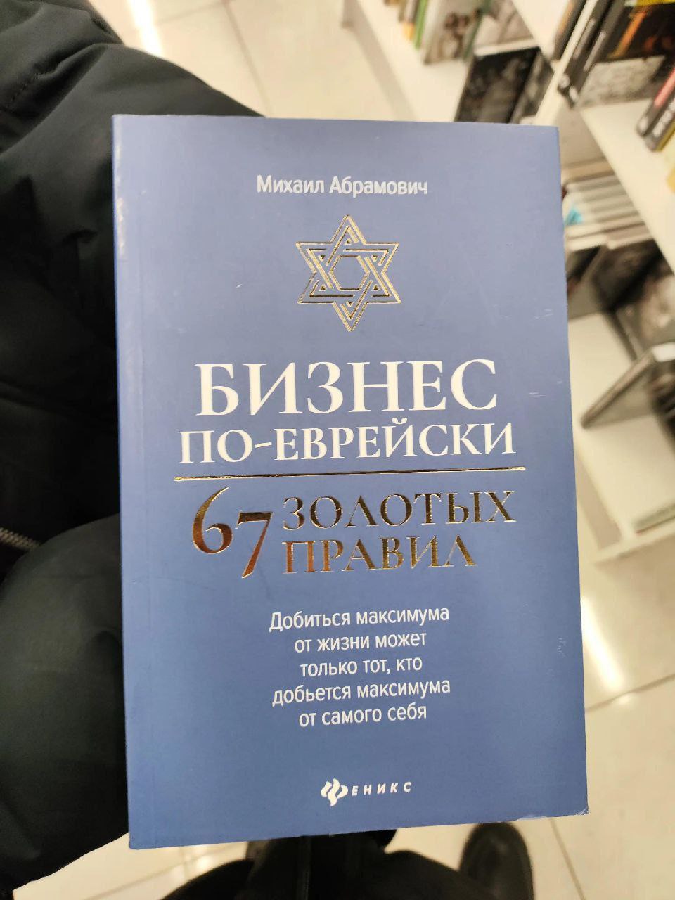Фотография книги «Бизнес по-еврейски: 67 золотых правил» Михаила Абрамовича с мотивационной цитатой на обложке.