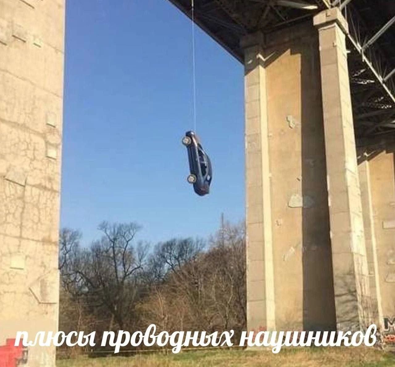 Плюсы проводных наушников Автомобиль висит на тонкой нити под мостом, а на переднем плане видна надпись: «плюсы проводных наушников»