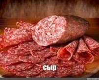 Сыр и колбаса Нарезанная колбаса на деревянной доске с надписью "сыр"