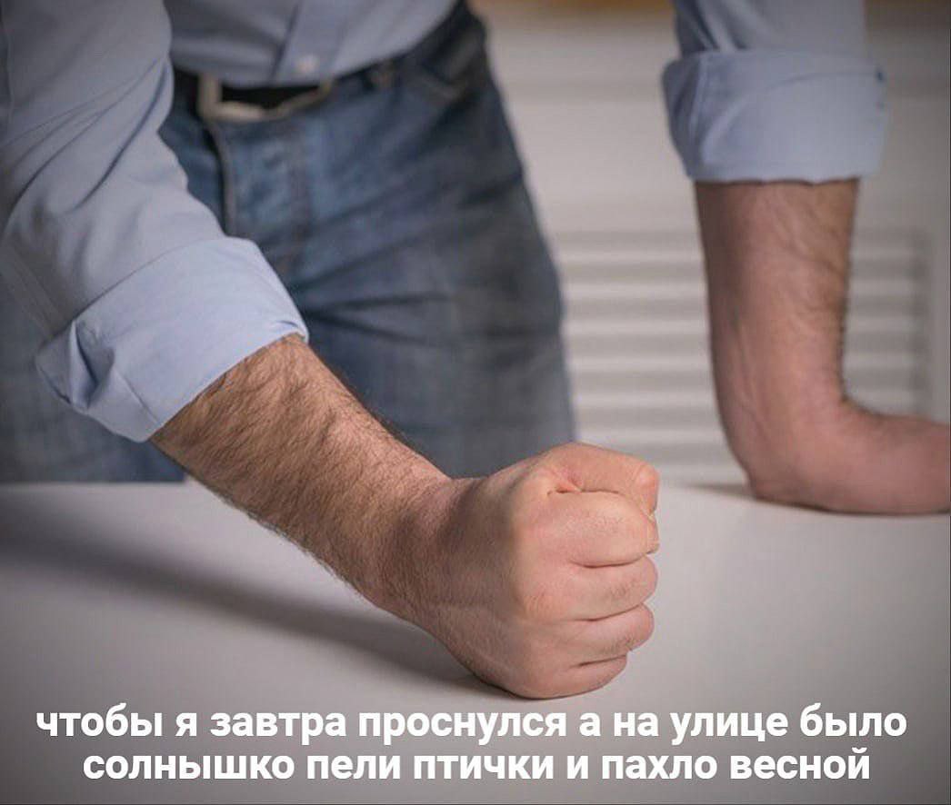 Чтобы я завтра проснулся а на улице было солнышко Мужчина в рубашке и джинсах сжимает кулак на столе, с пожеланием солнечной весны