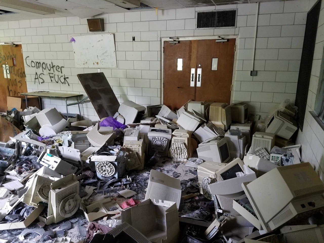 Заброшенная комната с кучей старых компьютеров и надписью «Computer AS FUCK»