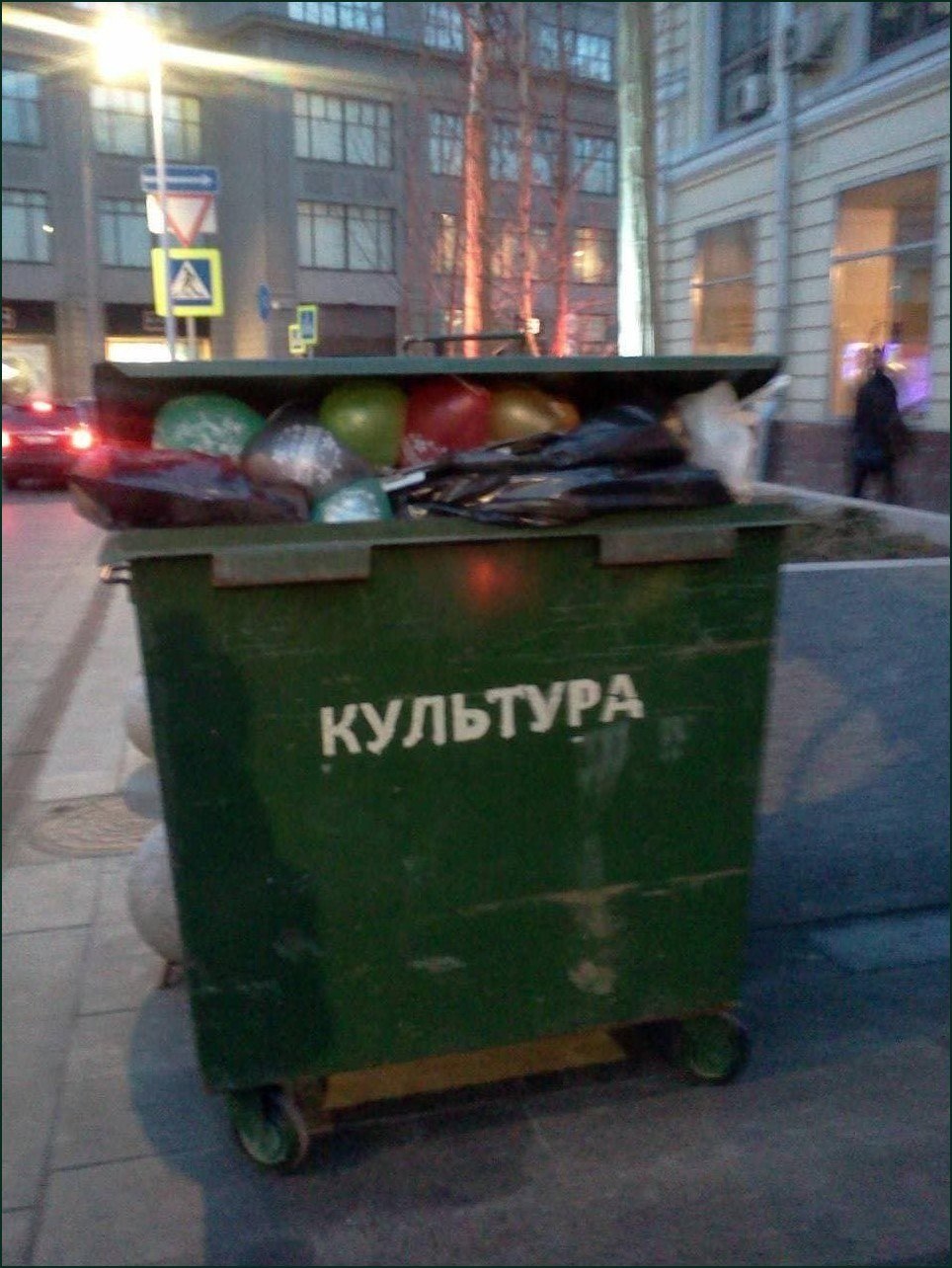 Мусорный контейнер с надписью «КУЛЬТУРА», наполненный пакетами и разным хламом