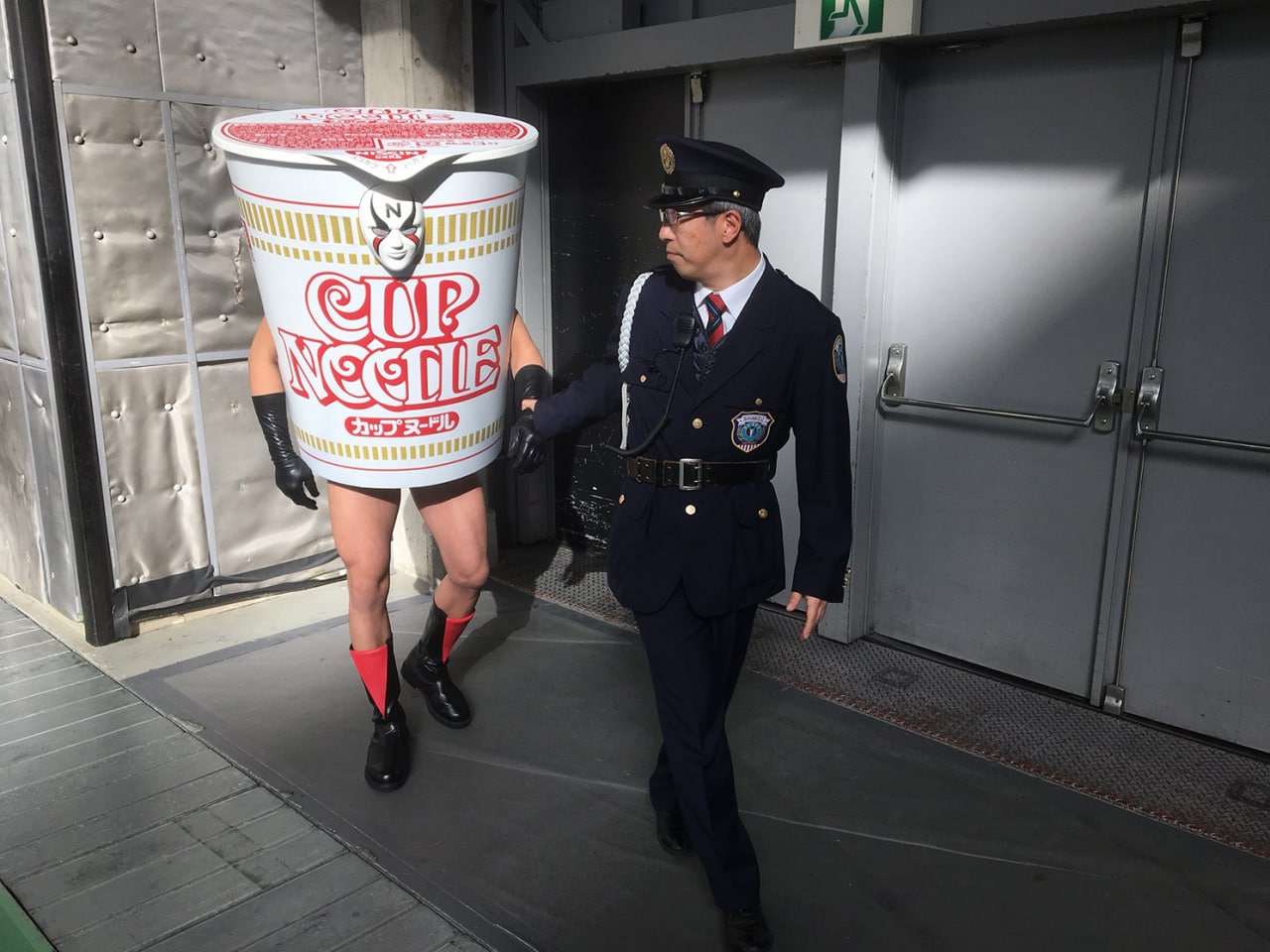 Арест Cup Noodle Полицейский арестовывает человека в костюме Cup Noodle