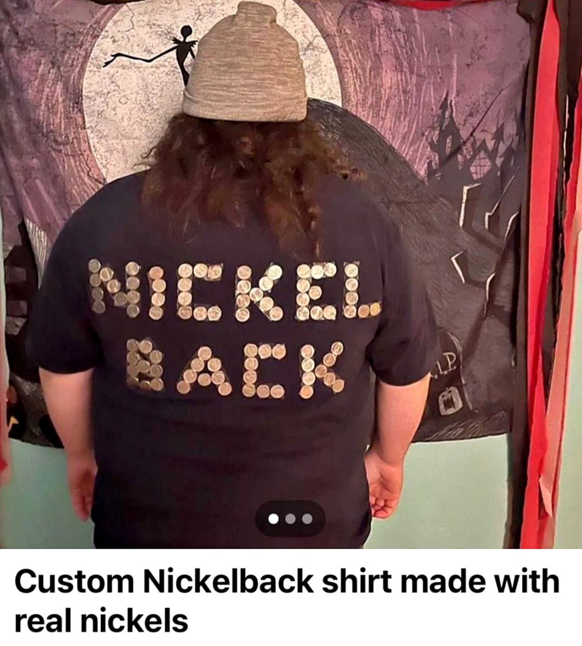 Custom Nickelback shirt made with real nickels Человек в шапке стоит спиной в черной футболке с надписью «Nickelback», выложенной монетами. На фоне виден плакат с Джеком Скеллингтоном.