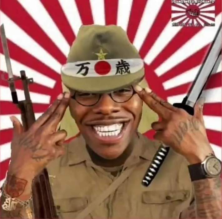 DaBaby в японской форме Мем с американским рэпером DaBaby, одетым в форму японского солдата времен Второй мировой войны, который делает жест «пистолет» у головы. На фоне изображен японский флаг.