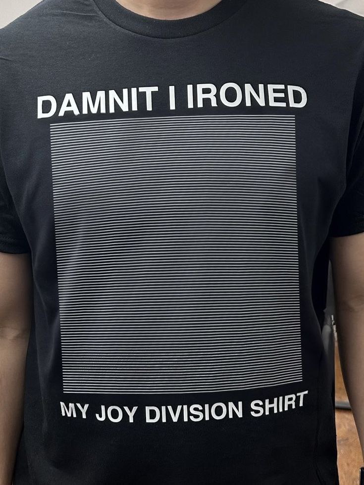 DAMNIT I IRONED MY JOY DIVISION SHIRT Человек в черной футболке "DAMNIT I IRONED MY JOY DIVISION SHIRT" с выглаженным принтом Joy Division