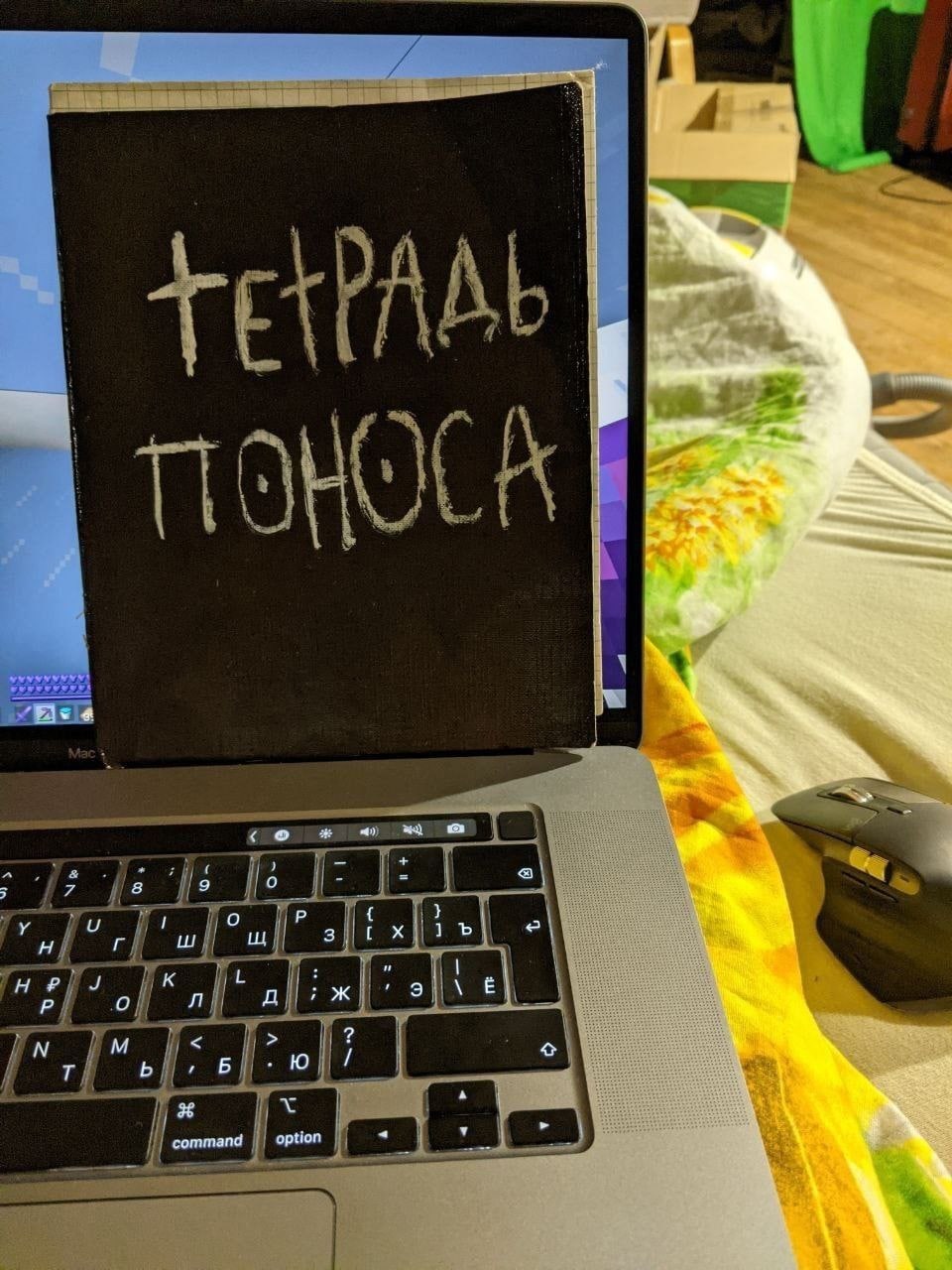 Тетрадь поноса Фотография открытого ноутбука с тетрадью поверх экрана, на которой написано "Тетрадь поноса"