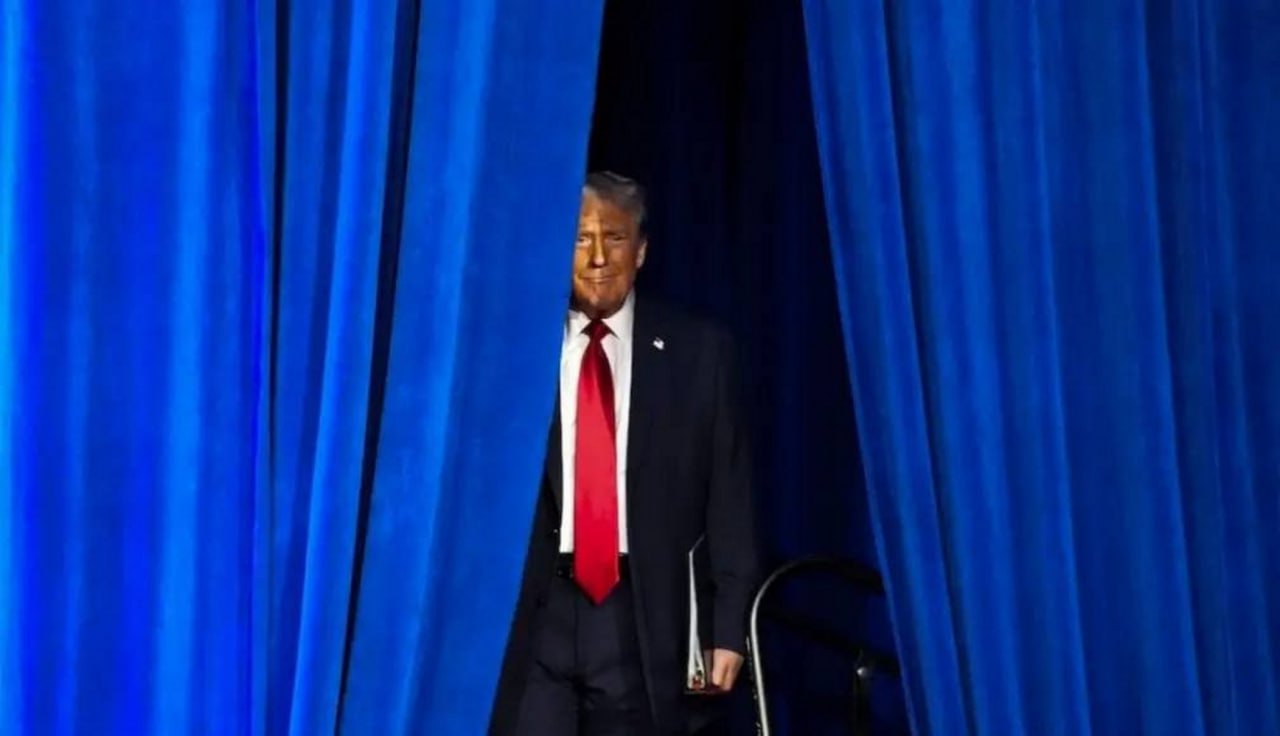 Дональд Трамп выглядывает из-за синих штор Дональд Трамп с хитрым выражением лица выглядывает из-за синих занавесок на мероприятии