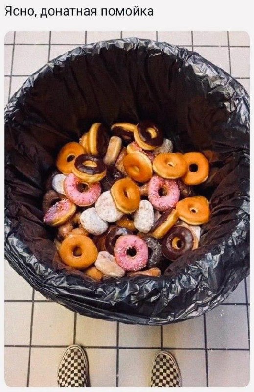 Помойка из пончиков Фотография большого количества пончиков разных цветов и вкусов, выброшенных в мусорное ведро с черным мусорным пакетом, на фоне плиточного пола. Сверху надпись "Ясно, донатная помойка".