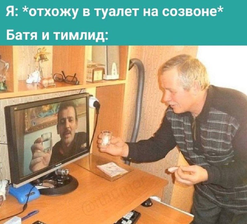 Пьют на созвоне Мужчина пьет водку со своим отцом/тимлидом, который отображается на мониторе во время видеозвонка.