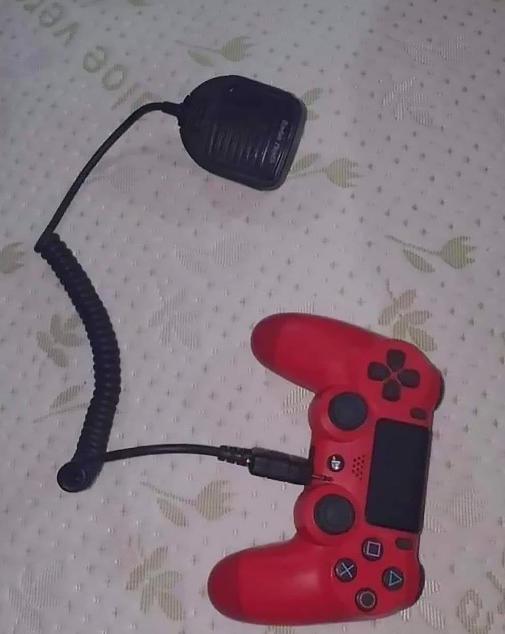 Джойстик с рацией Красный джойстик PlayStation 4, к которому подключен черный радиопередатчик