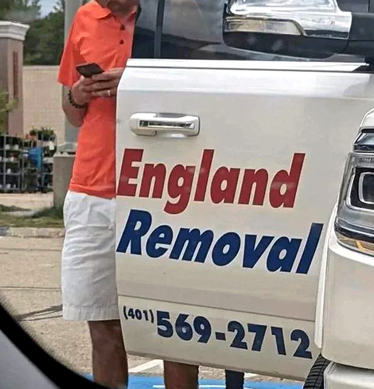 England Removal Мужчина стоит рядом с грузовиком компании «England Removal» с номером телефона.