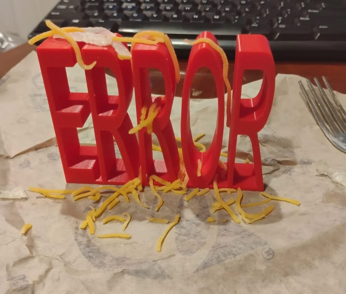 ERROR с сыром Красные 3D-буквы "ERROR" посыпаны сыром чеддер на бумажной салфетке