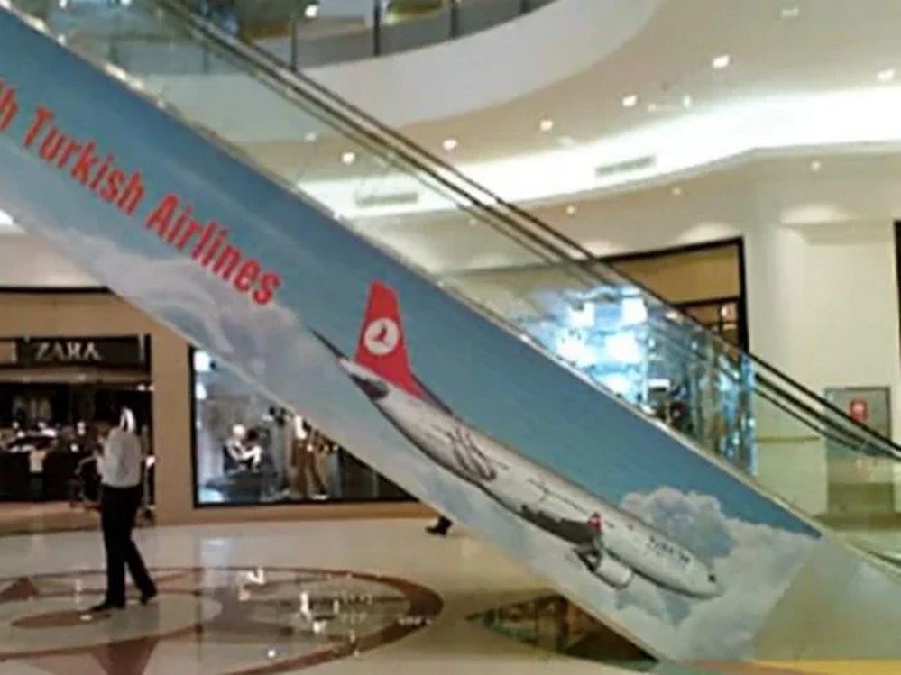 Эскалатор с самолётом Turkish Airlines Эскалатор, на котором нарисован самолёт турецких авиалиний, взлетающий на фоне голубого неба с облаками