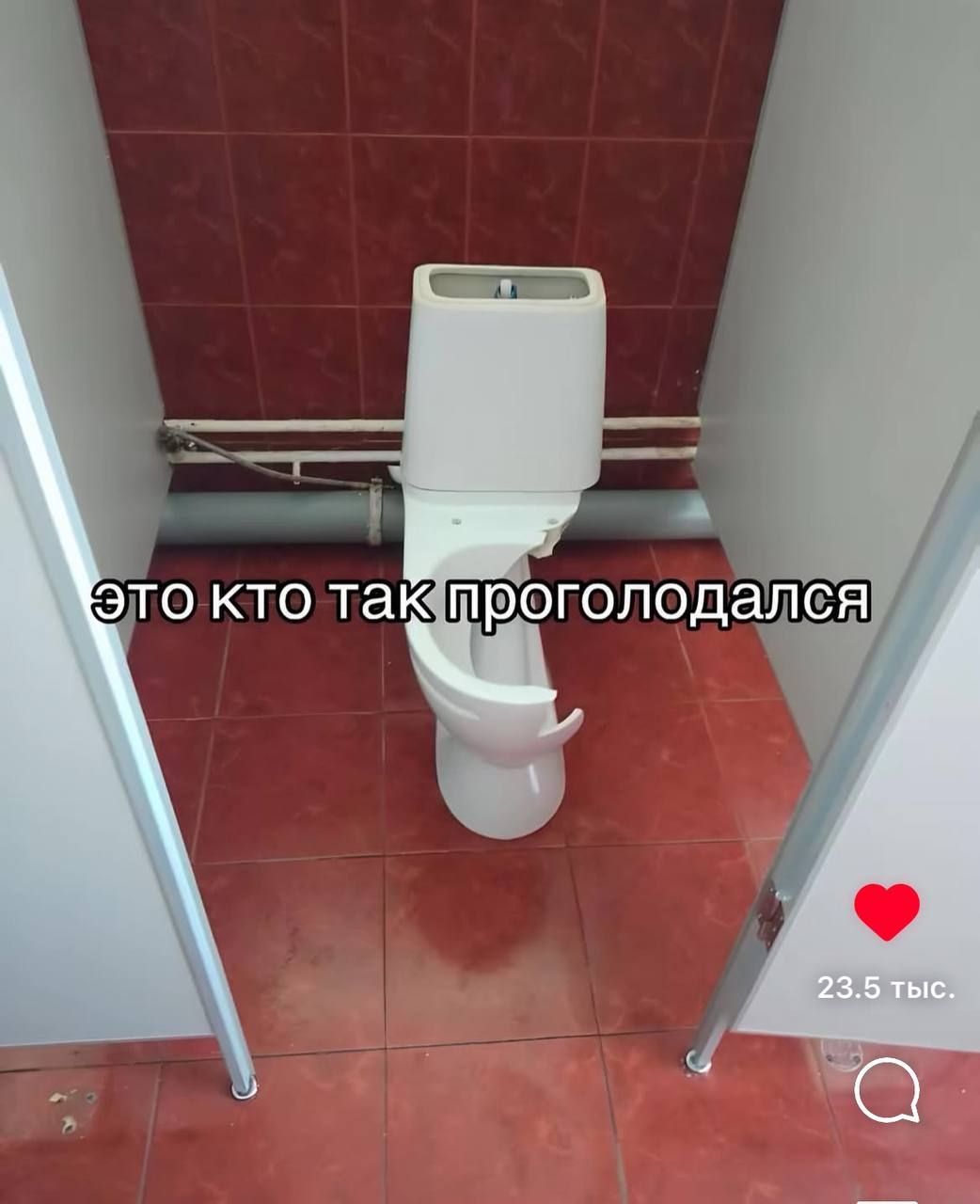 Это кто так проголодался Сломанный унитаз со сколом в туалетной комнате с красной плиткой и надписью «Это кто так проголодался».