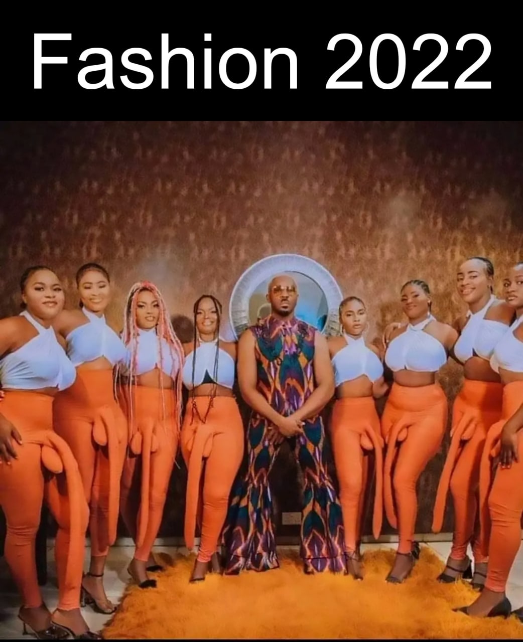 Fashion 2022 Мужчина в ярком костюме и восемь женщин в леггинсах с фаллоимитаторами