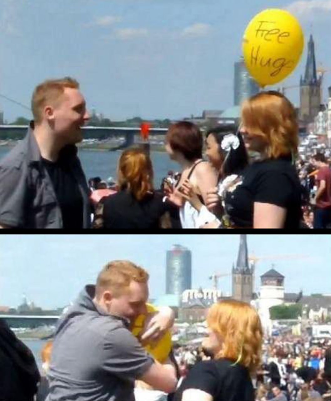 Free Hugs Девушка с рыжими волосами протягивает воздушный шар с надписью «Бесплатные объятия» парню, который радостно обнимает ее в ответ, на фоне реки и города