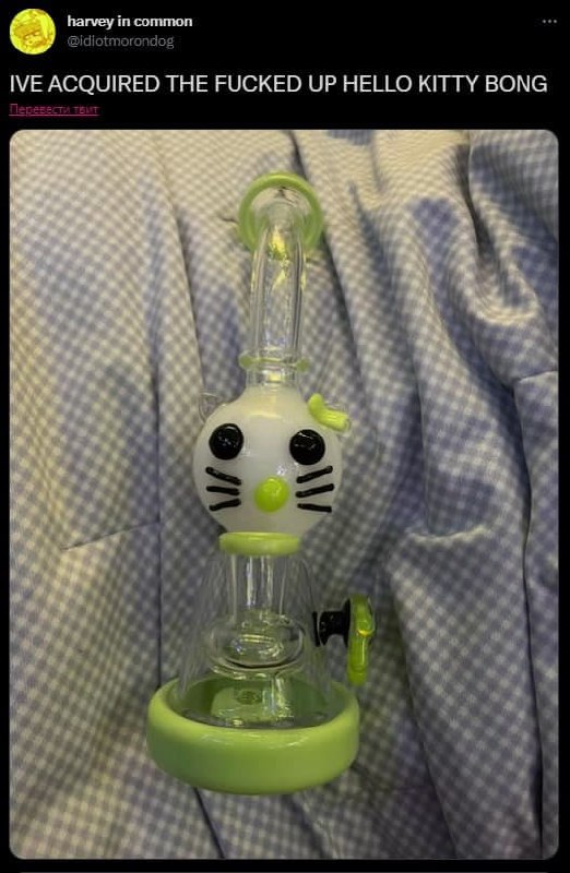 Ебаный бонг Hello Kitty Бонг в виде головы Hello Kitty с салатовыми деталями на фоне клетчатой ткани