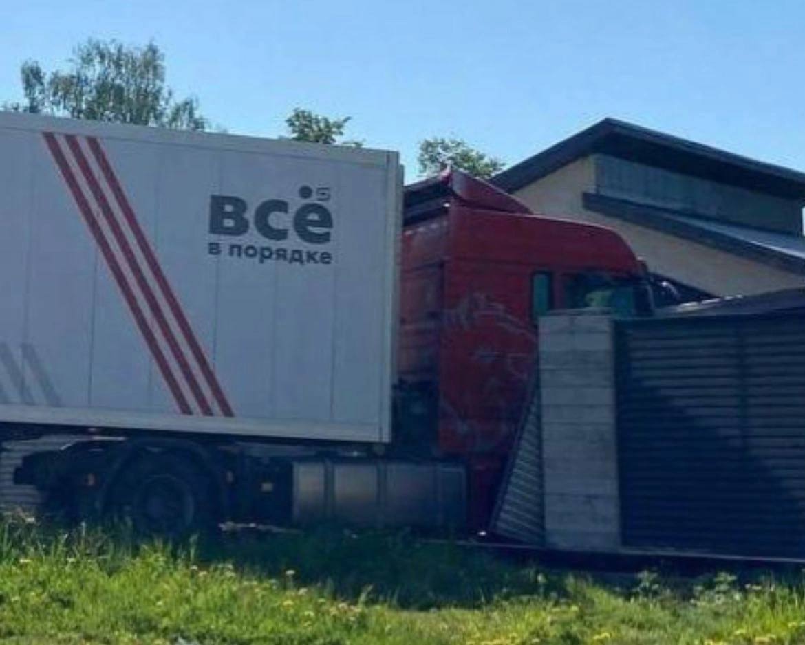 Фура врезалась в дом с надписью "Всё в порядке" Красная фура врезалась в дом, на прицепе которой написано "Всё в порядке"
