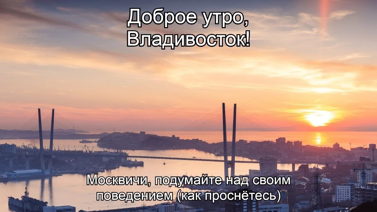 Рассветный Владивосток с видом на мосты и бухту, сопровождаемый шутливым обращением к москвичам: подумайте над своим поведением, когда проснётесь.
