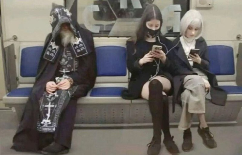 Готический пассажир метро и две девушки в телефонах