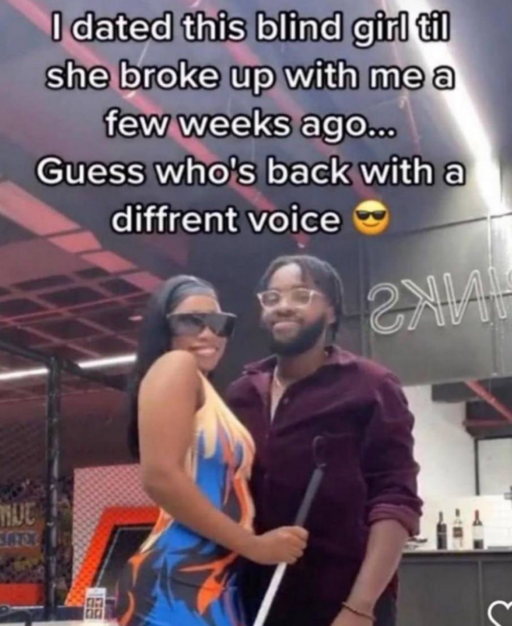Guess who's back with a different voice Мужчина со слепой тростью улыбается рядом с женщиной в ярком платье и солнцезащитных очках.
