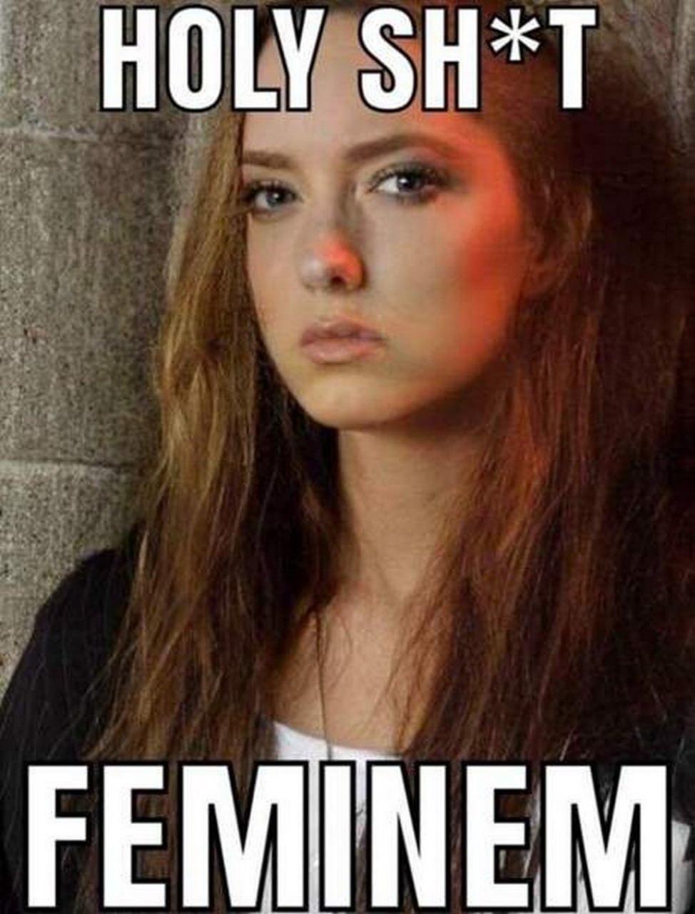 Holy sh*t, Feminem На картинке изображена молодая женщина с длинными русыми волосами, светлыми глазами и макияжем, ее выражение лица задумчивое или слегка удивленное. На ней черная одежда и белая футболка. Сверху надпись "HOLY SH*T", а снизу "FEMINEM".
