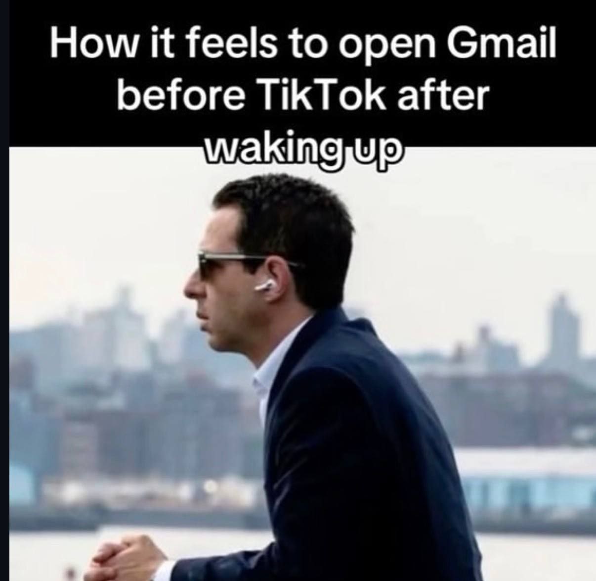 How it feels to open Gmail before TikTok Мужчина в костюме и наушниках смотрит вдаль на фоне города, иллюстрируя ощущение открытия Gmail вместо TikTok утром