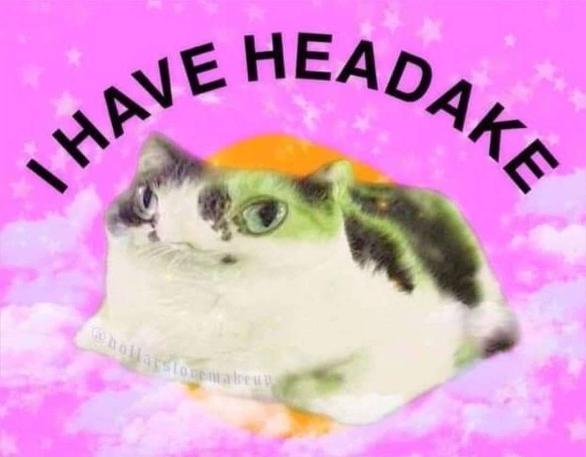 Недовольный кот на розовом фоне с надписью «I have headache» — «У меня болит голова».