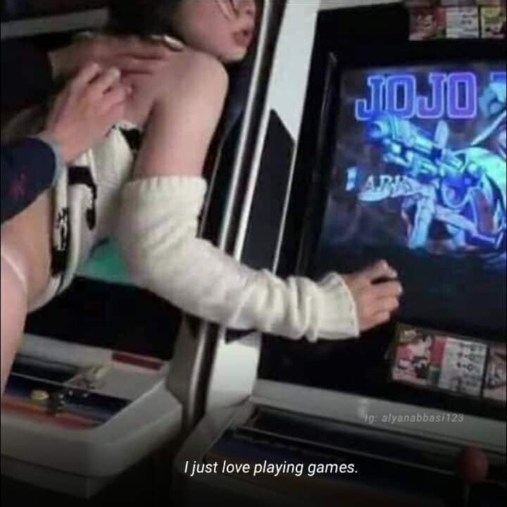 I just love playing games Девушка в откровенной одежде играет в аркадные игры, а сзади её трогает мужская рука.