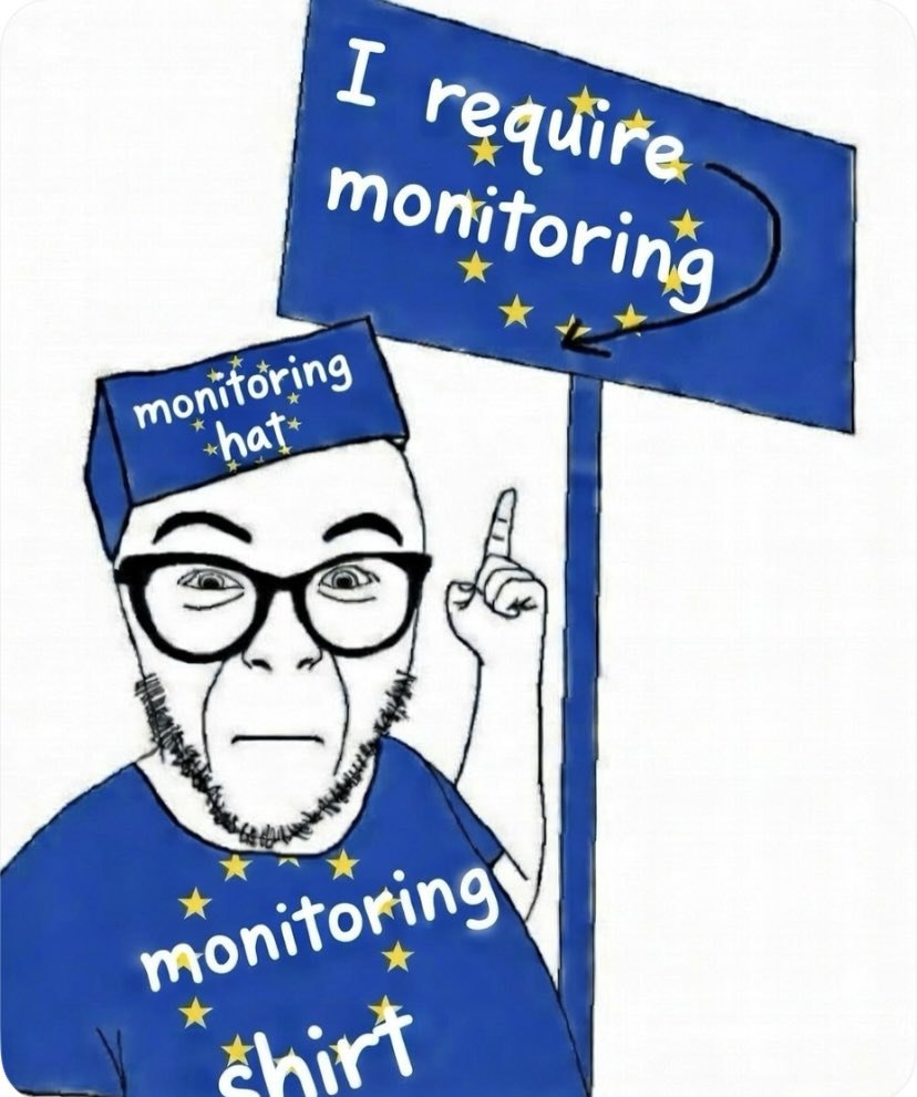 Человек в шапке и футболке с надписью «monitoring» у знака «I require monitoring» — «Мне требуется наблюдение».