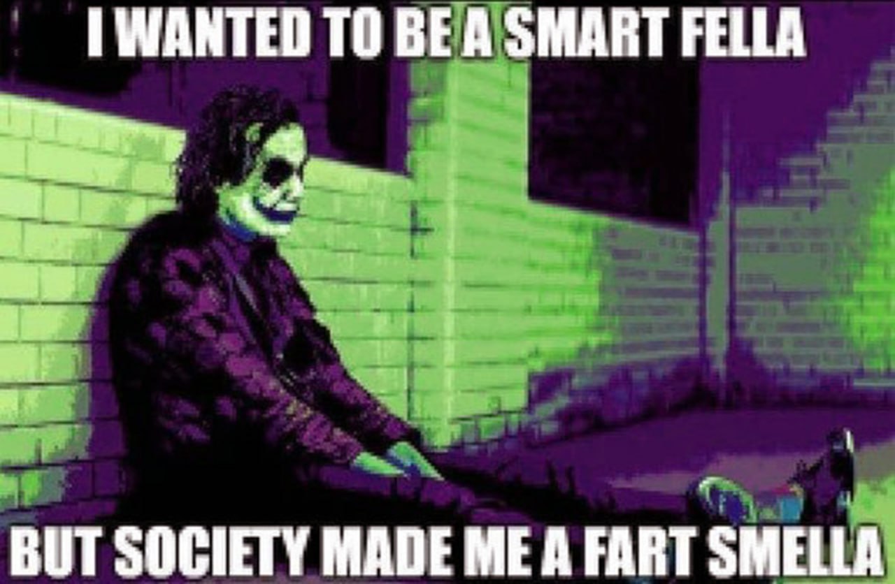 I wanted to be a smart fella Грустный Джокер сидит на земле на фоне кирпичной стены, освещенной фиолетовым и зеленым светом.