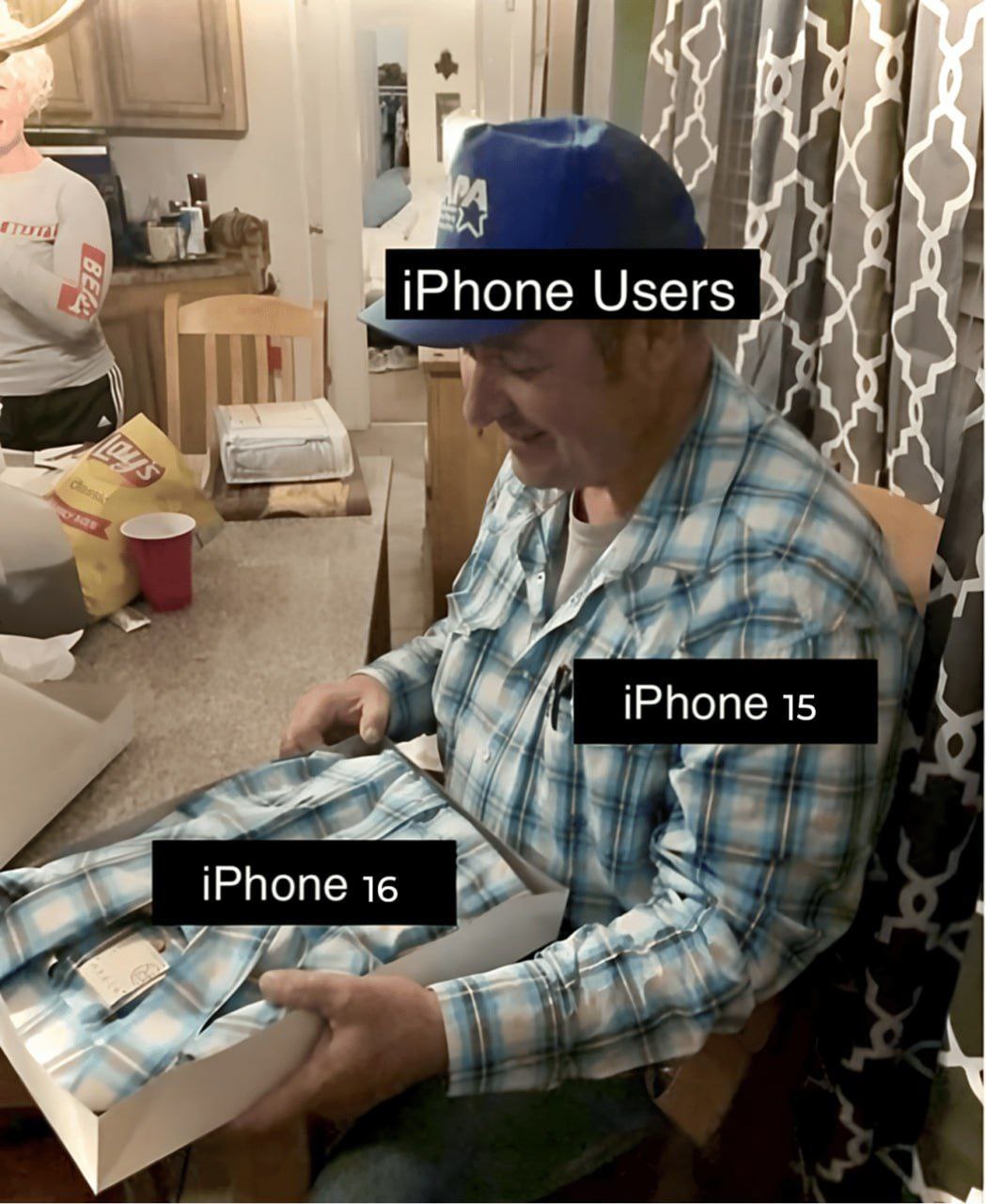Пользователи iPhone получают ту же рубашку Мем с мужчиной, который открывает подарок, а там такая же рубашка, как у него уже есть, символизирует разочарование пользователей iPhone от новой модели.