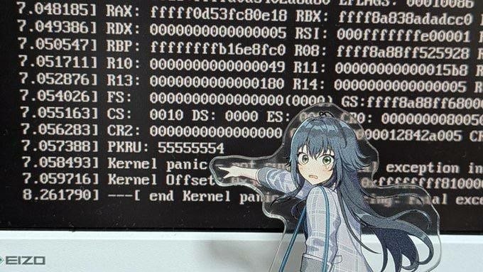 Аниме-девушка указывает на экран монитора с сообщением Kernel panic и диагностическим текстом Linux.
