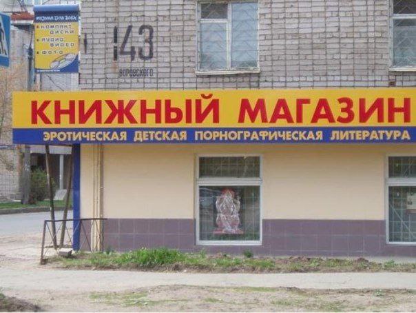 Вывеска книжного магазина с надписью «эротическая детская порнографическая литература» на фасаде здания.