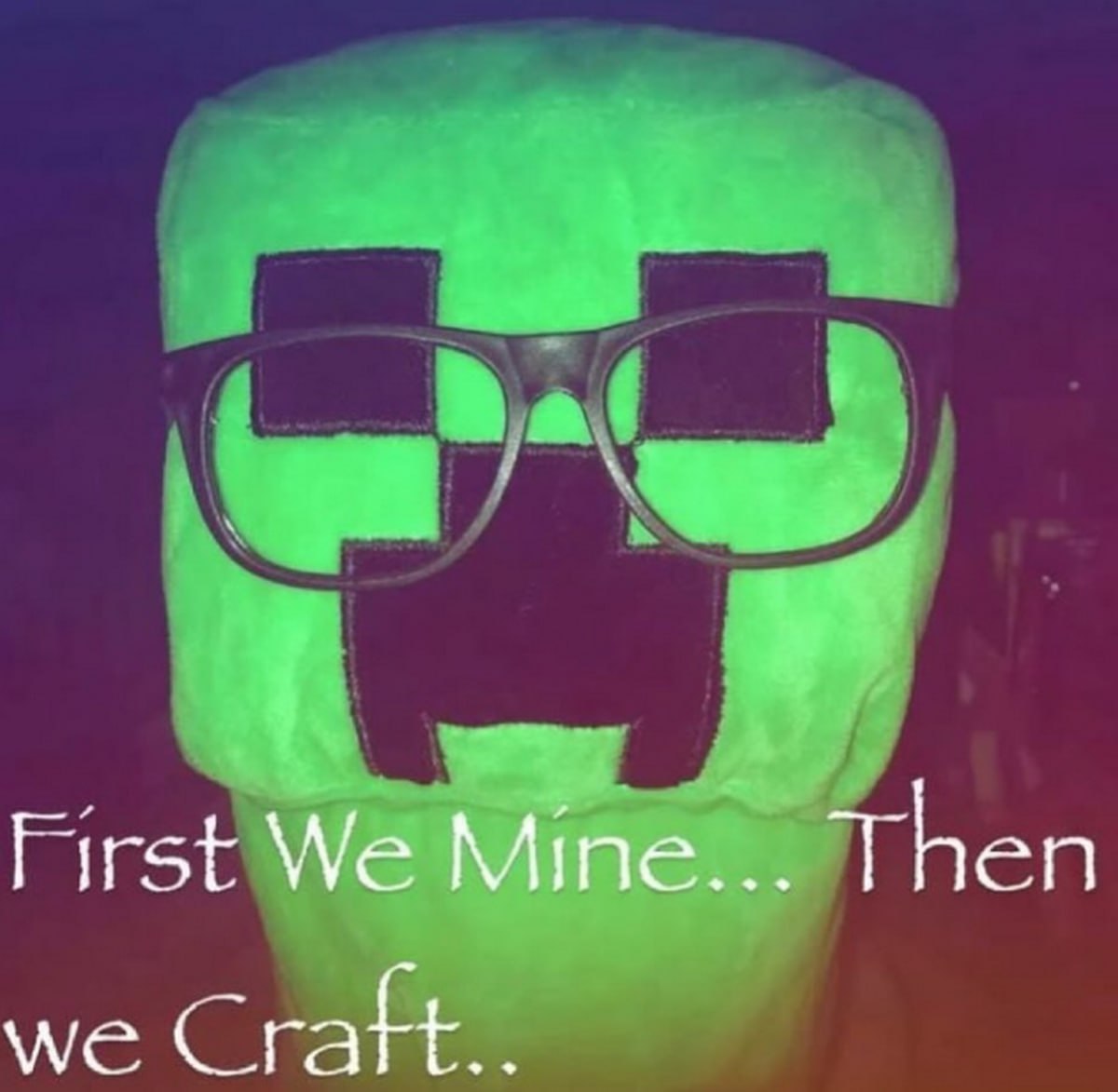 Крипер в очках "First We Mine... Then we Craft..." Мягкая игрушка "Крипер" из Minecraft в очках, на фоне темного фона с фиолетовым и синим оттенком.