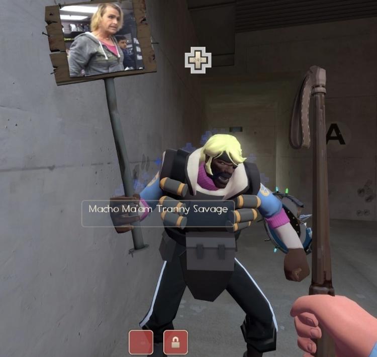 Macho ma'am tranny savage Персонаж игры Team Fortress 2 с ником «Macho ma'am tranny savage» держит табличку с изображением Дольфа Лундгрена в женском образе.