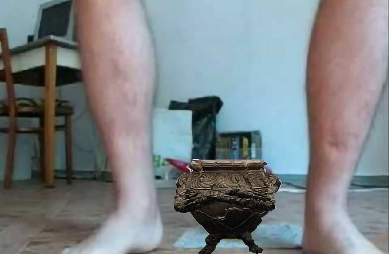 Ноги над банкой Элден Ринг Мем с изображением ног человека, стоящего над маленькой банкой-кувшином из игры Elden Ring, снятый на камеру снизу.