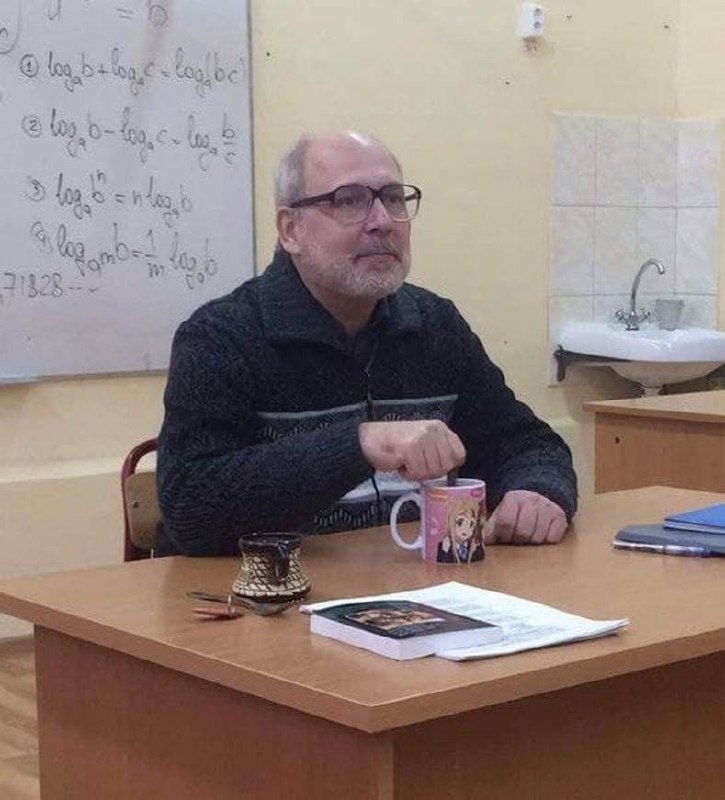Мужчина с аниме-кружкой в классе Мужчина в очках сидит за столом с кружкой, на заднем плане математические формулы и раковина