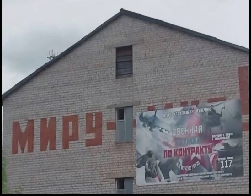Надпись "МИРУ-" на кирпичной стене и баннер "Военная служба по контракту"
