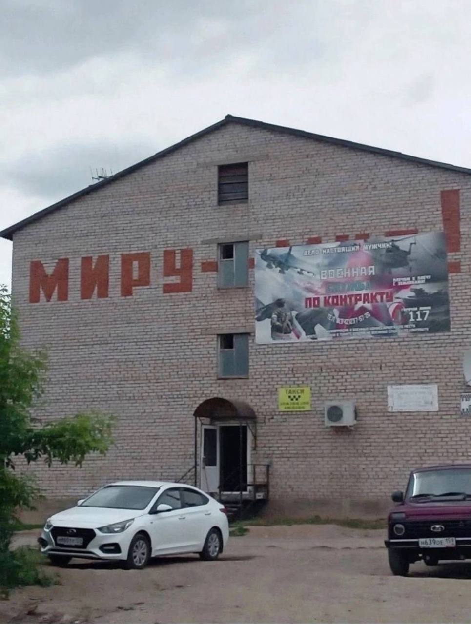 Миру - военная служба по контракту Надпись «Миру —» на стене здания и баннер «Военная служба по контракту» рядом