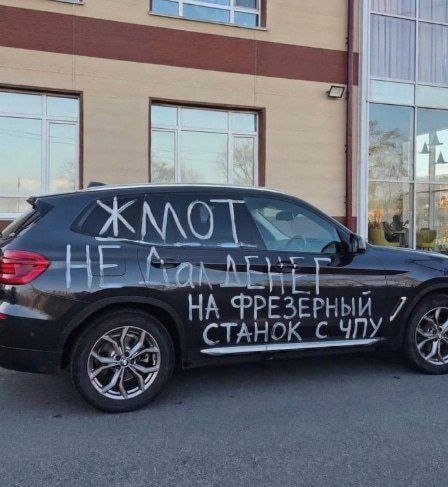На черном автомобиле белой краской написано: «Жмот не дал денег на фрезерный станок с ЧПУ».