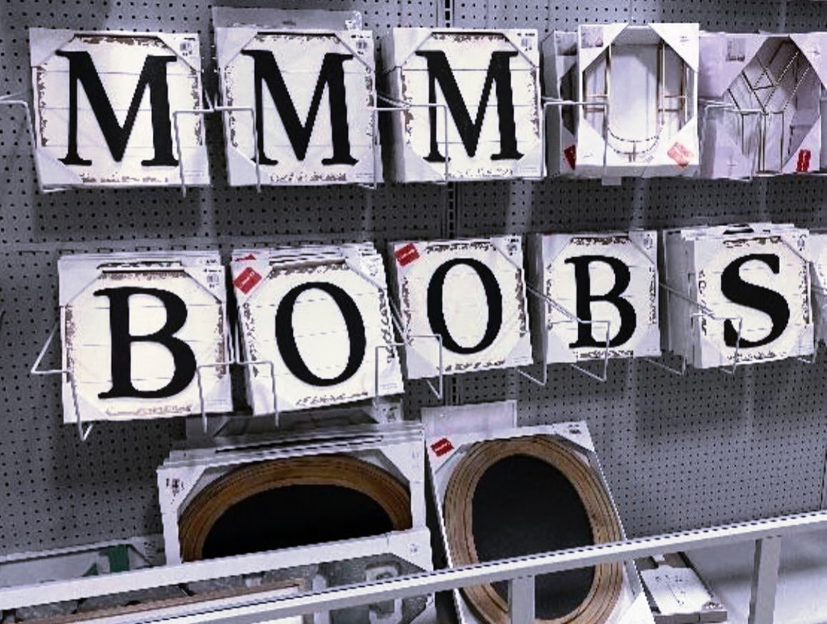 МММ BOOBS Надпись МММ BOOBS из табличек с буквами на витрине магазина.